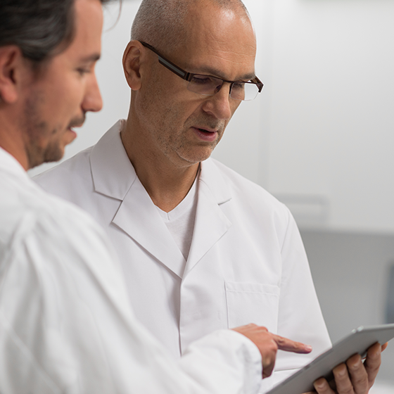 Image of two surgeons reviewing a study on an iPad
